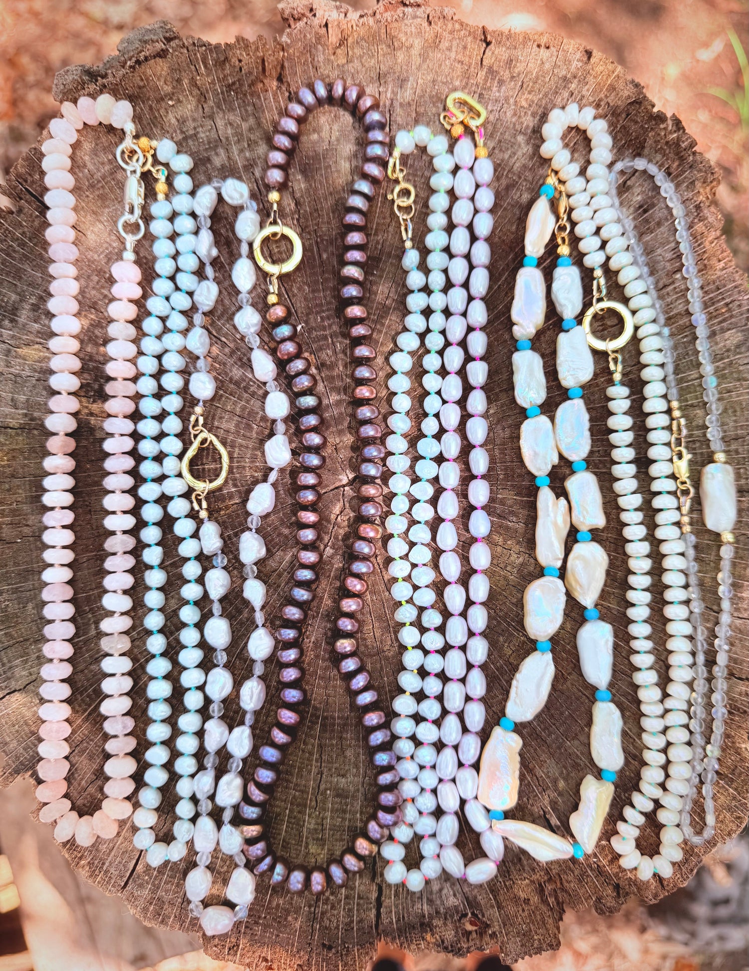 Mixed necklaces made of pearls, precious gemstones displayed across a natural setting